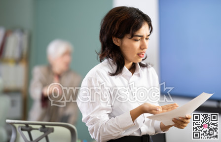 Upset young girl being scolded by manager in background