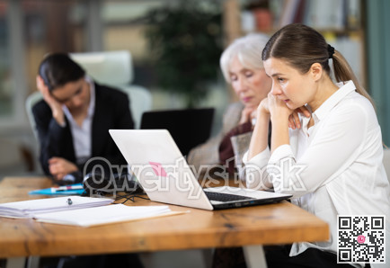 Adult woman sitting tired and sad at office desk