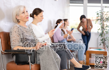 Bored elderly woman waiting for appointment with doctor in clinic