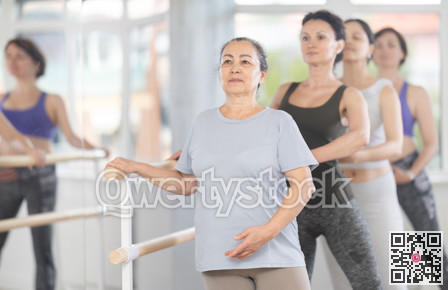 Senior woman practicing battement tendu in beginner ballet class