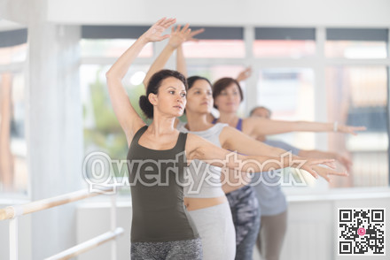 Woman practicing ballet moves during amateur group class