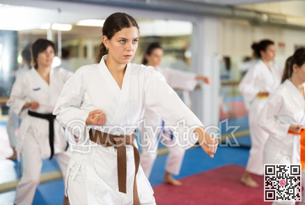 Women in self-defense training in white kimono with belts