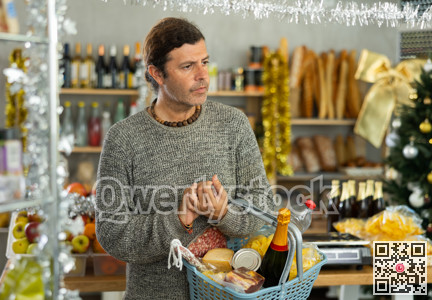 Customer with shopping basket browsing aisles of festive grocery store