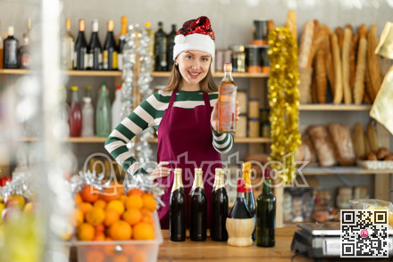 Female vendor in Santa Claus hat offers to buy wine and other products for the festive table on Christmas