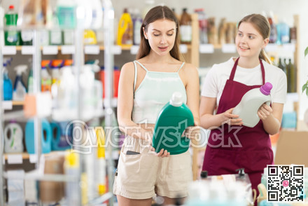 woman, with the help of a supermarket seller, chooses a detergent