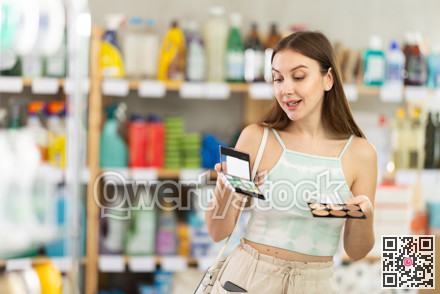 Woman in summer clothes choosing a set of cosmetics in a supermarket