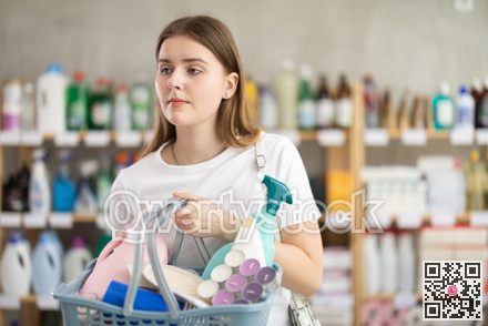 Young woman chooses household chemicals in store