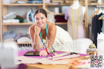 Female tailor create sketch of dress in tablet