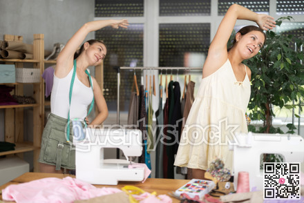 Female dressmakers doing a warm-up in the workshop in summer