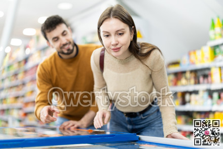 Couple spends time in store, looking for necessary goods and get out from refrigerator