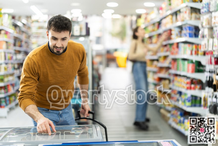 Man spends time in store, looking for necessary goods and get out from refrigerator