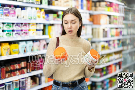 Positive woman buyers chooses shampoo or shower gel in household chemicals store