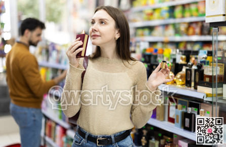 Young woman chooses perfume in store