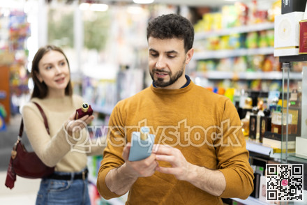 Couple choosing bottle of perfume in perfume shop