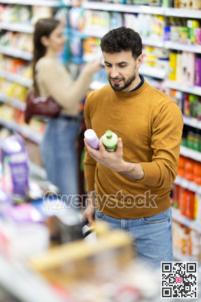 Male shopper is shopping in a supermarket, buying body care products