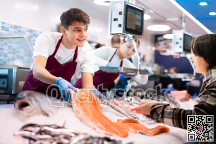 Portrait of man offering female customer fresh fish at seafood shop