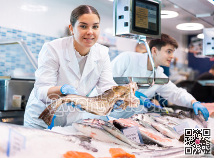 Female seller of fish department of a supermarket demonstrates fresh atlantic cod