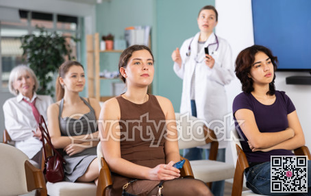 Group of women watching presentation with doctor in background
