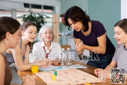Group of women playing board game around a table