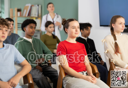 Schoolchildren carefully watch a lecture in the classroom against the background of a a doctor teacher