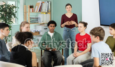 Group of boys and girls sits in a circle in the classroom