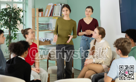 Teenage girl stands in a circle in front of other schoolchildren