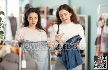 Young girls choosing jeans pantaloons in clothing store