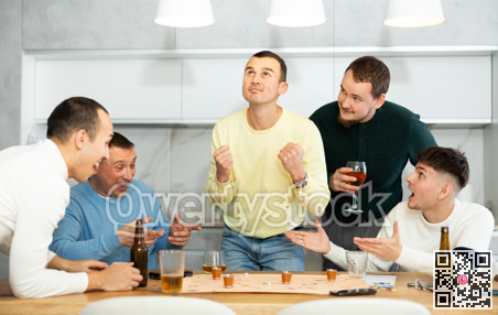 Group of cheerful men engaged in alcohol-fueled board game