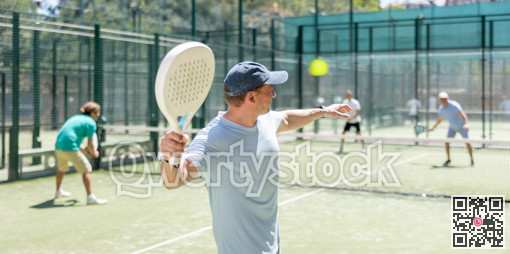 Men play padel on an outdoor tennis court. Hitting the ball with racket