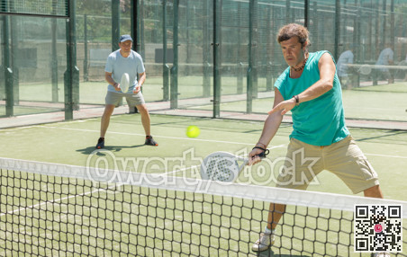 Two adult men playing doubles padel