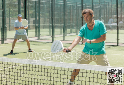 Men play padel on an outdoor tennis court. Hitting the ball with racket
