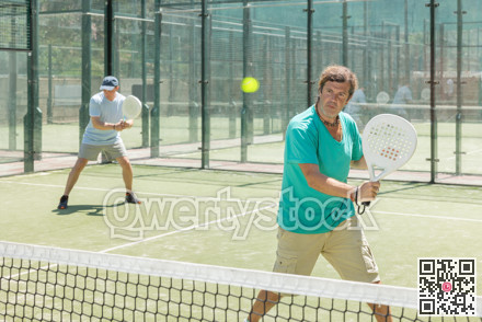 Padel game - man with partners plays on court