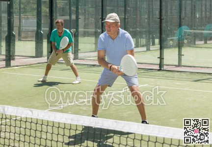 Elderly and adult men playing doubles padel