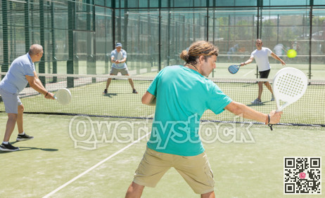 Padel game - man with partners plays on court