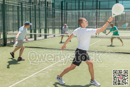 Men play padel on an outdoor tennis court. Hitting the ball with racket