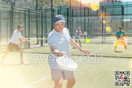 Adult and young men playing padel against two men