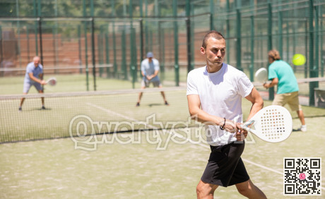 Adult and young men playing padel against two men