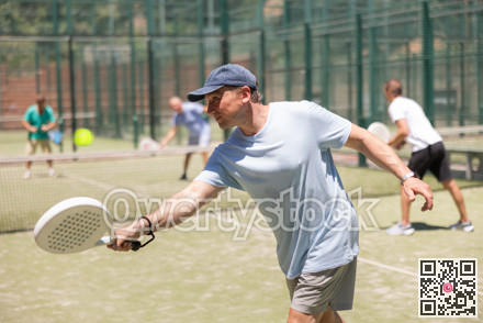 Adult and young men playing padel against two men