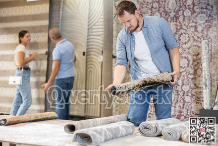 On territory of exhibition hall, guy inspect carpets