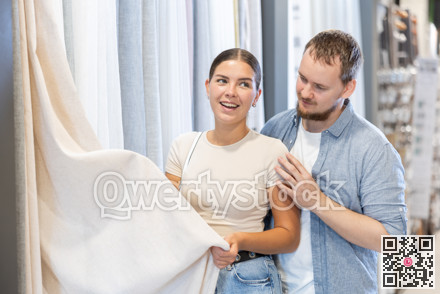 Couple touches and feels product, chooses curtains for windows.