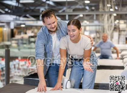 Couple man and woman choosing bed in store