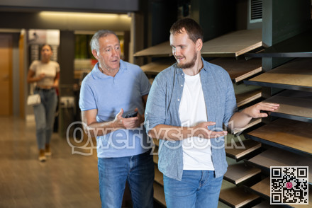 Mature man and guy son carefully examine wooden finishing material