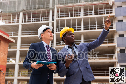 Two architect, civil engineer or building contractor colleagues on construction site
