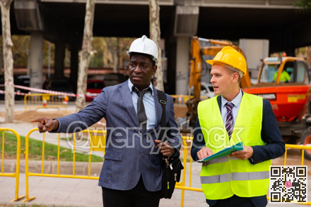 Architect tells engineer where to dig a trench to lay pipe