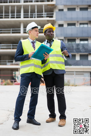 Engineer and architect discusses construction plan at construction site outdoor