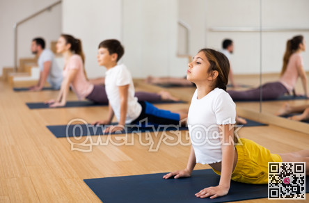 Girl exercising cobra pose during family yoga training