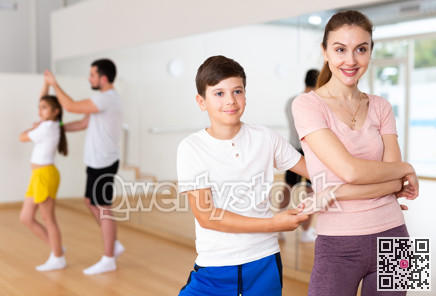 Tween boy enjoying active dance in pair with mother