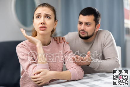 Apologetic husband calming upset wife after spat at home