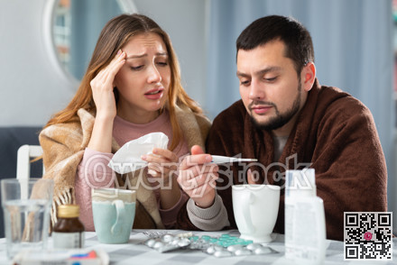Woman and man wrapped in plaids having symptoms of cold at home