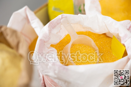 Ground corn in large woven bags in store